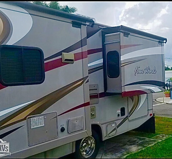 Side view of a Four Winds Class C motorhome with a slide-out extended, ideal for your next rv rental journey.. Other Four Winds 2016