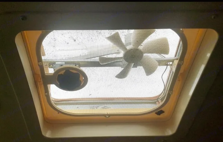 Overhead view inside an RV rental: A ceiling vent with a fan, protective screen, and control knob for airflow.. Other Four Winds 2016