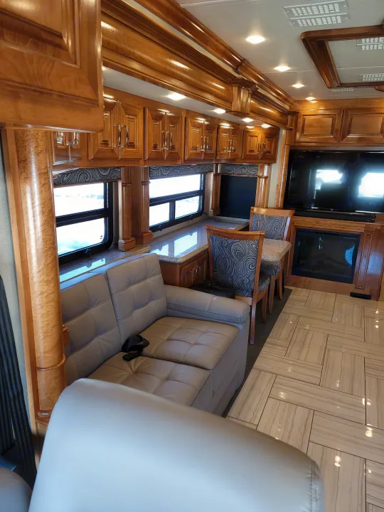 Inside a luxury RV rental: rich wood, smart TV, cozy fireplace, comfy leather seating, and stylish tile floor. High-end living.. American Revolution 2019