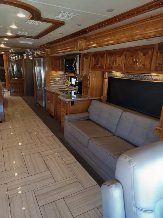 Experience luxury RV rental living: a sophisticated interior featuring polished wood, a gourmet kitchen, plush seating, and stylish tile.. American Revolution 2019