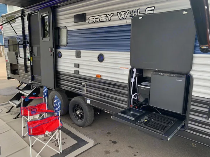 This RV rental boasts an amazing outdoor kitchen: fridge, sink, grill, and chairs. Ready for your next camping adventure & outdoor cooking!. Cherokee Grey Wolf 27DBH 2021