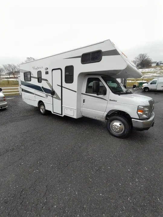 White Class C Wayfarer RV rental parked on asphalt, overcast day background.. Tiffin Motorhomes wayfarer 2020