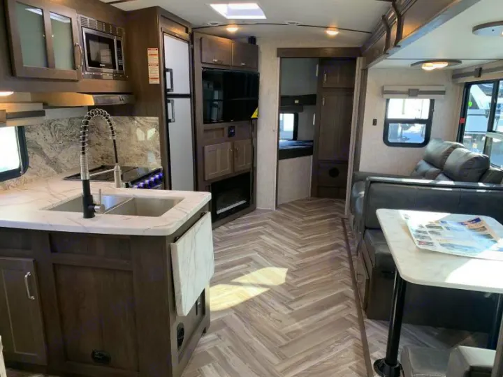 Explore this spacious RV rental interior: a fully-equipped kitchen, comfortable living area, and bunk beds.. Dutchmen Denali 2021
