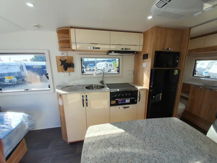This RV rental's modern kitchen features a sink, stove, microwave, and refrigerator, next to a cozy dining/living space.. Avan Aspire 555 2021