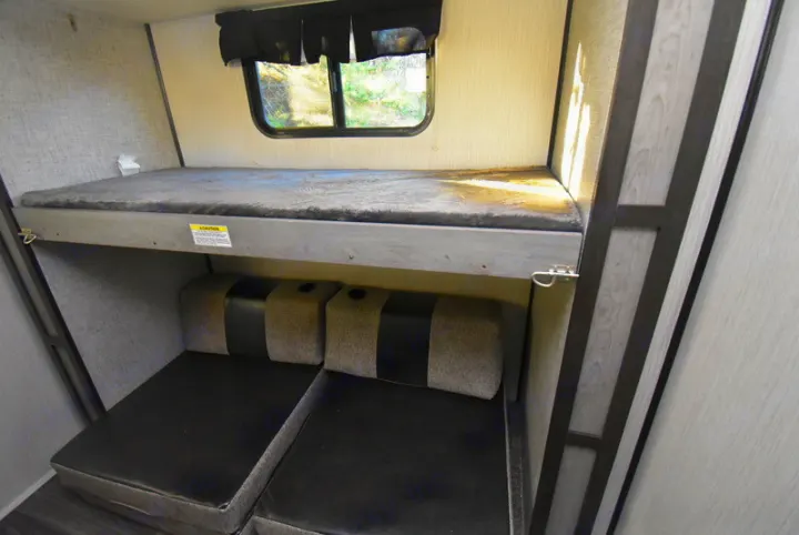 Compact RV rental interior featuring a comfy top bunk bed and versatile lower seating, ideal for travel adventures.. Other M-3385 2020