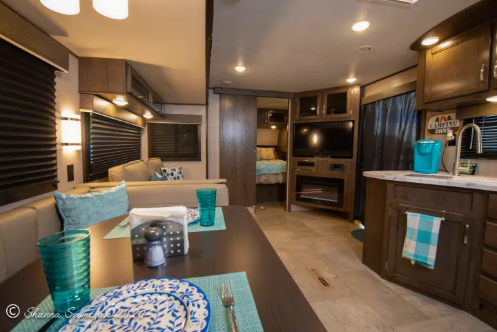 Spacious RV rental interior featuring a dining table, sofa, full kitchen with coffee maker, & entertainment center.. Jayco Jay Flight 2020