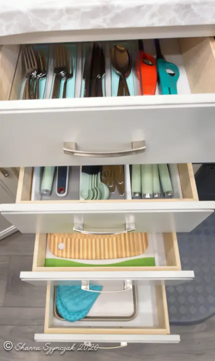 Neatly organized kitchen drawers in an RV rental, featuring silverware, cooking utensils, a cutting board, and oven mitts with a tray.. Jayco Jay Flight 2021