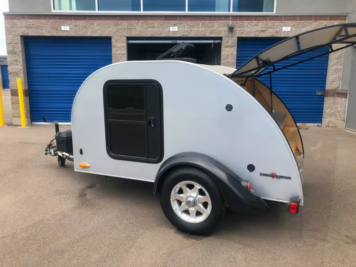 This compact Silver Shadow teardrop camper is an ideal RV rental, shown parked at a storage facility.. Little Guy 5x8 Silver Shadow 2008