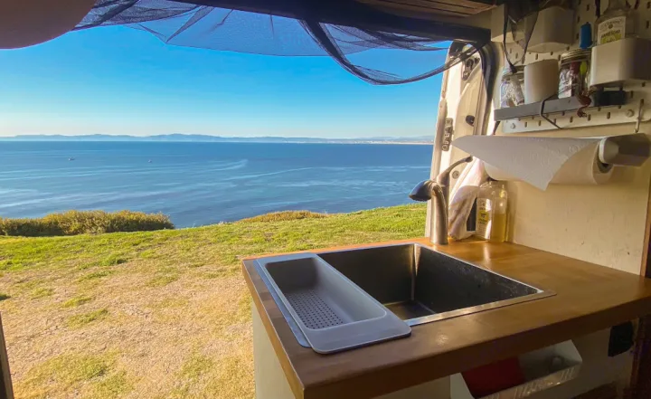 RV rental: Stunning ocean views from a cozy camper van kitchen with sink, perfect for coastal travel.. Ford Transit 2017