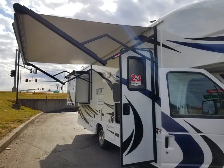 An Odyssey Entegra RV rental, parked with its awning and slide-out extended, showing the white exterior.. Entegra Coach Other 2021