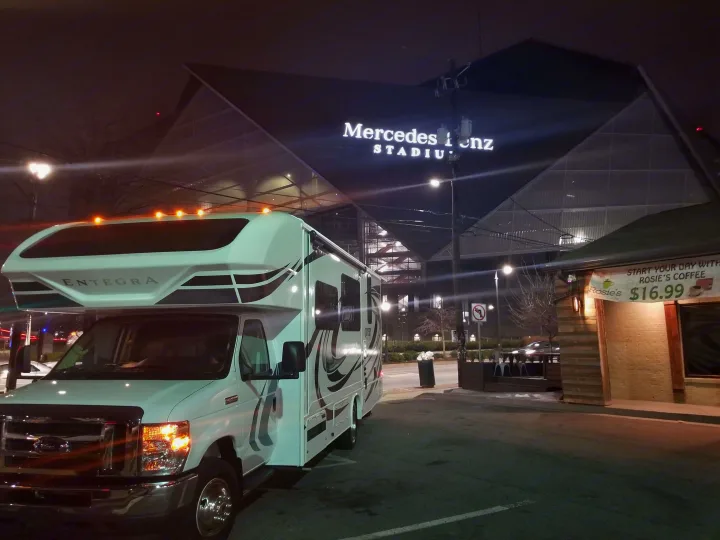 Entegra RV rental parked outside Mercedes-Benz Stadium at night, with Rosie's Coffee nearby.. Entegra Coach Other 2021