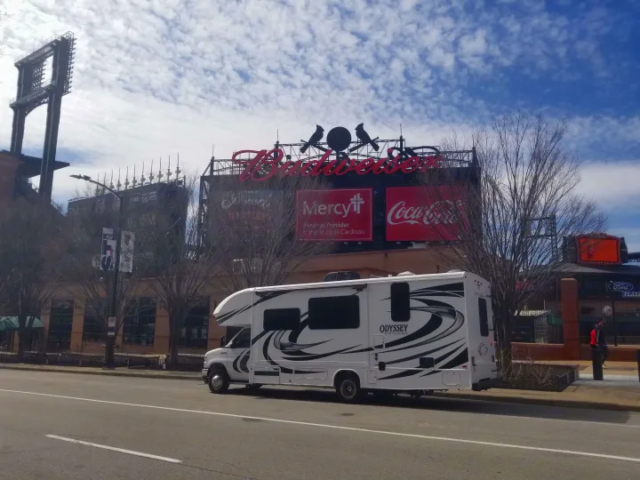 White **rv rental** parked on a street near Busch Stadium, featuring its iconic Budweiser, Mercy, and Coca-Cola signs.. Entegra Coach Other 2021