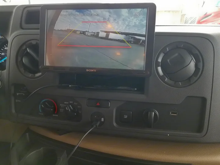 RV rental dashboard displays a Sony backup camera view with safety warning, alongside climate controls and USB charging.. Entegra Coach Other 2021