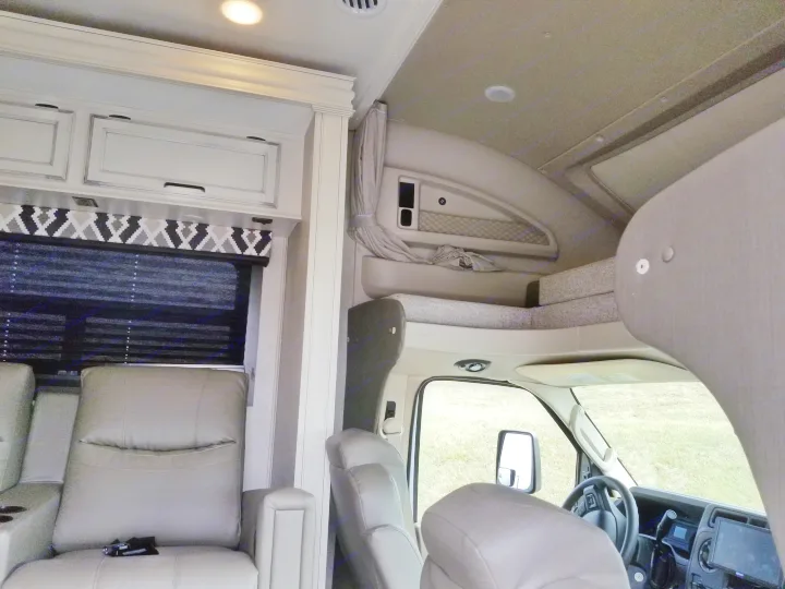 RV rental interior showing living area recliners, overhead cabinets, and front bunk with driver's cabin.. Entegra Coach Other 2021