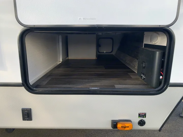 Explore an RV rental's spacious pass-through storage! Features an NCommand system, solar plug, and slide-out controls.. Keystone Cougar Half-Ton 2021