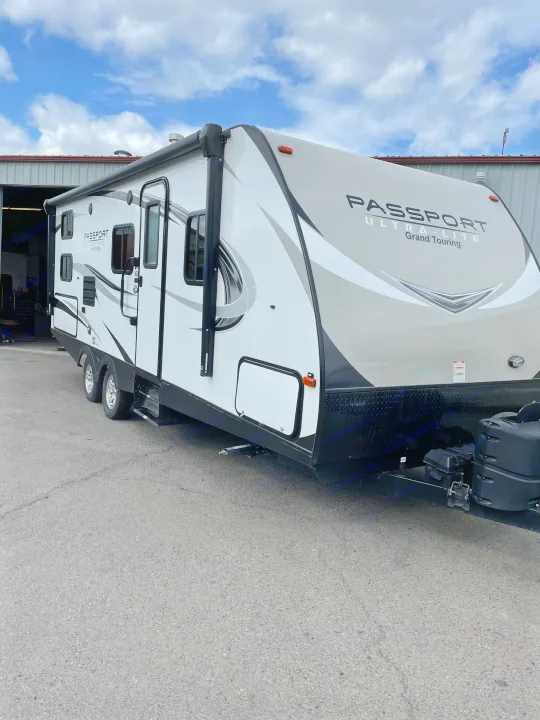 A clean white and grey Passport Ultra-Lite travel trailer. This RV rental is ready for your next adventure.. Keystone Passport 2400BHWE 2018