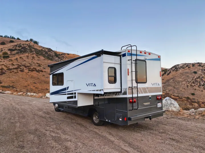 Winnebago Vita RV rental parked on a dirt road amidst dry hills, ready for an adventure.. Winnebago Porto 2020