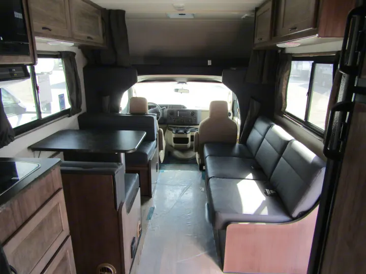 Interior of an RV rental: view from rear, showing dinette (left), sofa (right), kitchen, and front cab area.. Winnebago Minnie Winnie 2020