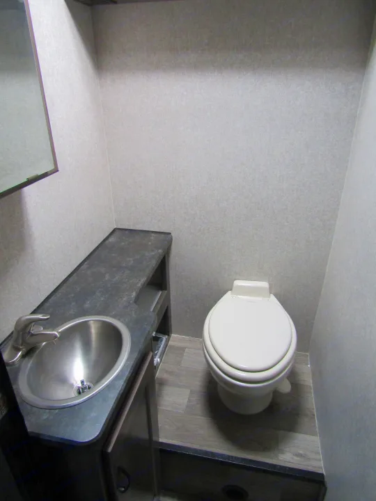 Compact RV rental bathroom featuring a sink, mirror, and toilet, designed for efficient space use.. Winnebago Minnie Winnie 2020