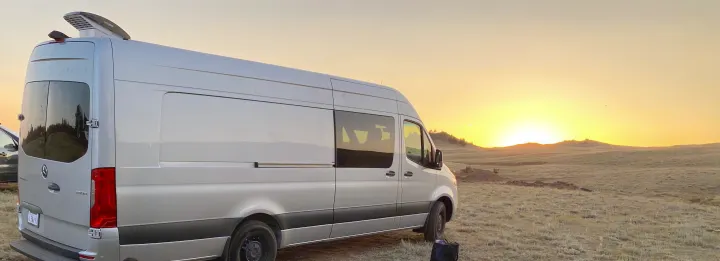 Experience an RV rental! Silver Sprinter van parked in a field with a vibrant sunset.. Other Sprinter 2019