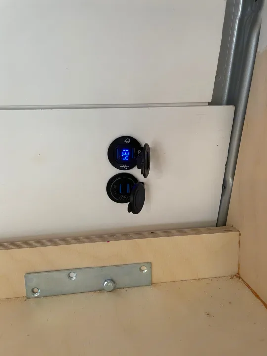 RV rental: 13.4V voltmeter & dual USB charging ports installed on white paneling for convenient power.. Other Sprinter 2019