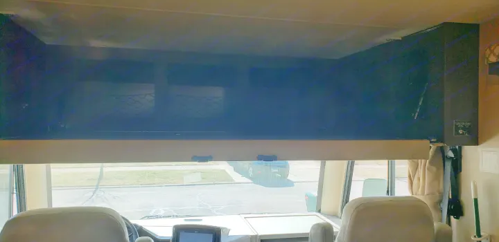 Inside an RV rental: a wide view of the front cabin area, featuring the dark cab-over bunk with storage nets.. Thor Motor Coach 30.3 2019