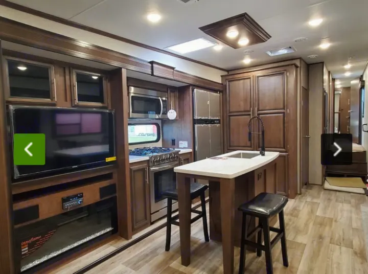 This spacious rv rental features a modern kitchen with an island, full appliances, and a living area with a TV and fireplace.. KZ Recreational Vehicles Durango 2021