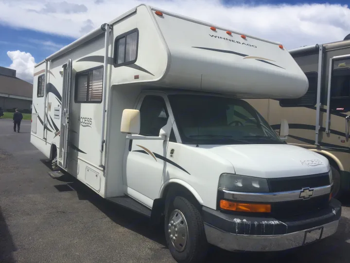 White Winnebago Access RV rental on a Chevy chassis, parked outdoors and ready for travel.. Winnebago Access 2007
