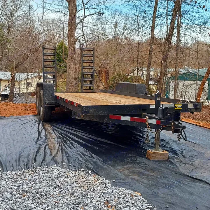 Black utility trailer on landscaping fabric & gravel, likely for site prep, not an RV rental.. Currahee SS 720 14K 2016