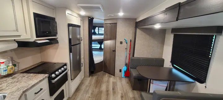 Spacious RV rental interior featuring a kitchen, dinette, and bunk beds. Ideal for family road trips.. Open Range 26BHS 2021