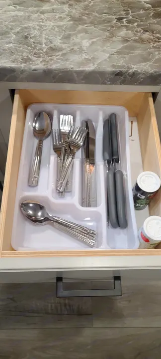 Neatly organized RV rental kitchen drawer with white cutlery tray holding knives, forks, spoons, and spice shakers.. Open Range 26BHS 2021