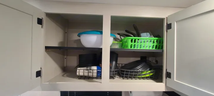 RV rental kitchen cabinet with neatly organized bowls, cooking utensils, and compact dishes for travel convenience.. Open Range 26BHS 2021