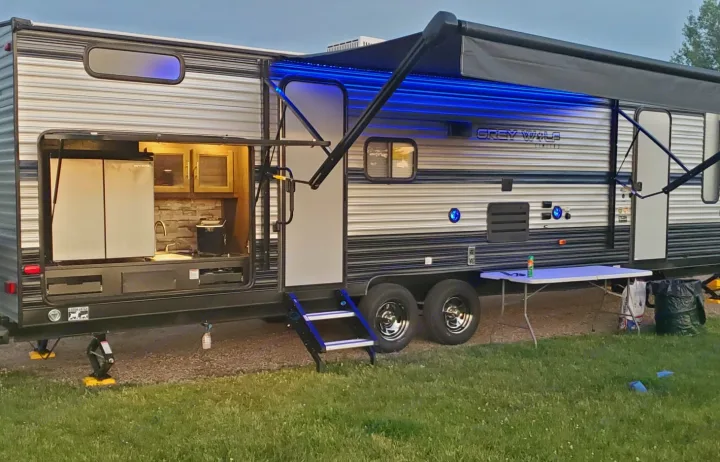 Spacious RV rental with an illuminated awning and convenient outdoor kitchen for comfortable camping adventures.. Forest River Grey Wolf 29te 2021