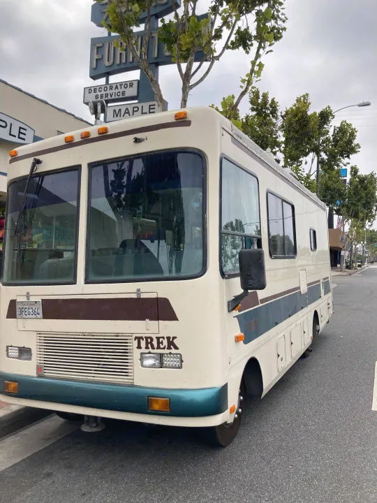 Spacious Trek RV, ideal for rv rental, parked on an urban California street near a furniture store.. Safari Trek 2610 1994