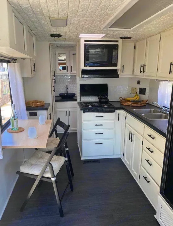 Spacious, modern RV rental kitchen with white cabinets, dark counters, and dining area. Perfect for a comfortable trip.. Safari Trek 2610 1994
