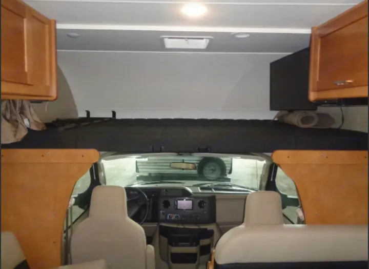 View inside an RV rental: features the comfortable cab-over bed, driver's cockpit, and front passenger seating.. Winnebago Minnie Winnie 2019