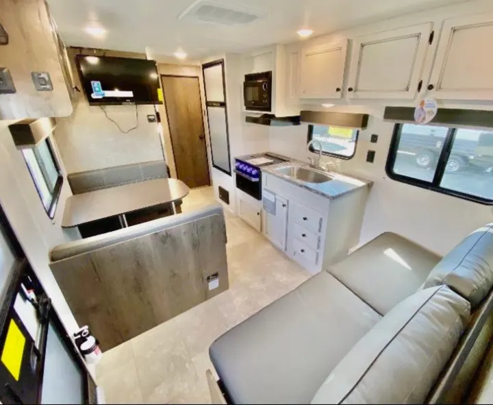 Step inside this RV rental! Features a fully equipped kitchen, a cozy dinette, and comfortable lounge seating.. Highland Ridge RV Open Range 2021