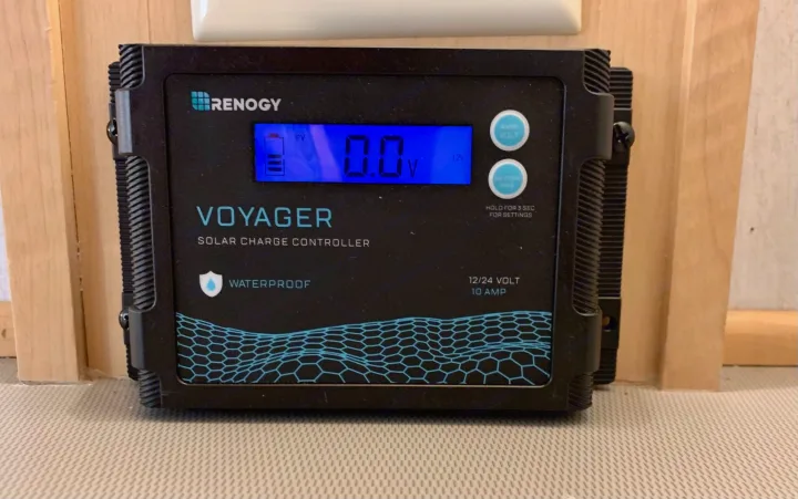 Black Renogy Voyager solar charge controller showing 0.0V, likely in an RV rental. Manages solar power for off-grid use.. Dutchmen T@b 2008