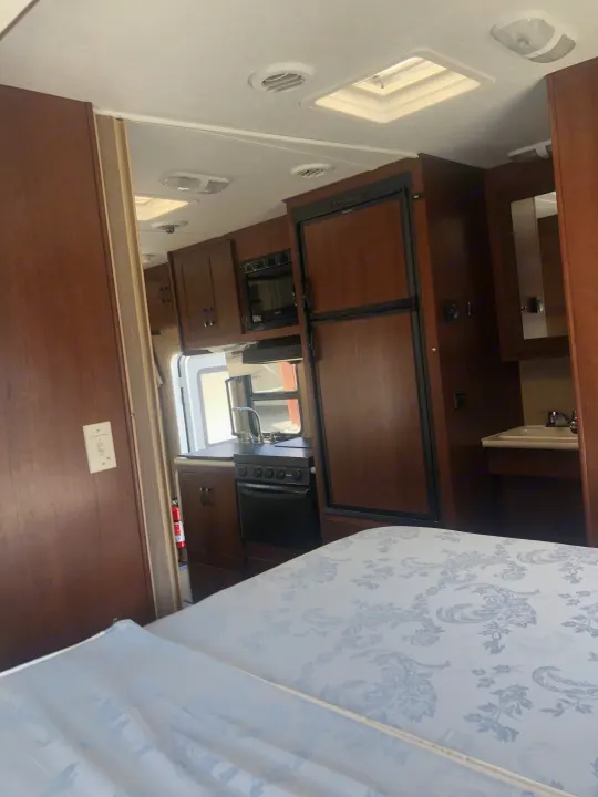 Experience this RV rental's cozy kitchen: refrigerator, microwave, stove, sink, and windows offer natural light.. Forest River Sunseeker 2014