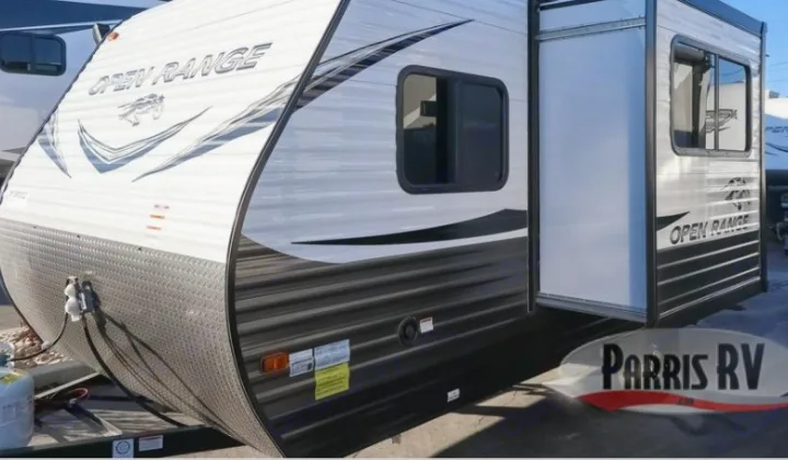 A white and black Open Range travel trailer, ideal for rv rental, showcasing its exterior with a slide-out.. Highland Ridge RV Open Range 2021