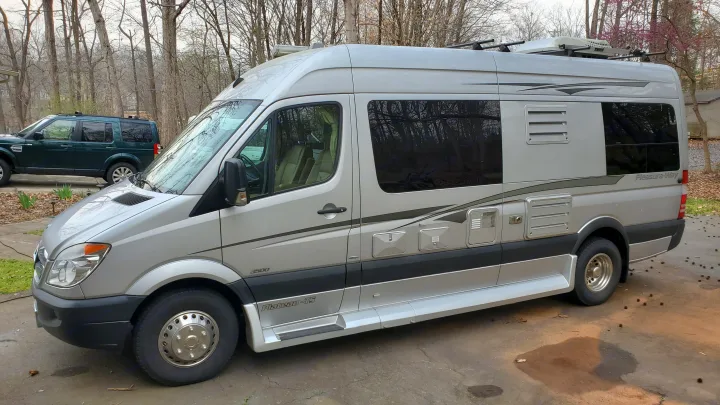 Silver Pleasure-Way Class B RV rental, built on Mercedes Sprinter chassis, parked on a paved lot. Ideal for road trips!. Pleasure Way Plateau Ts 2013