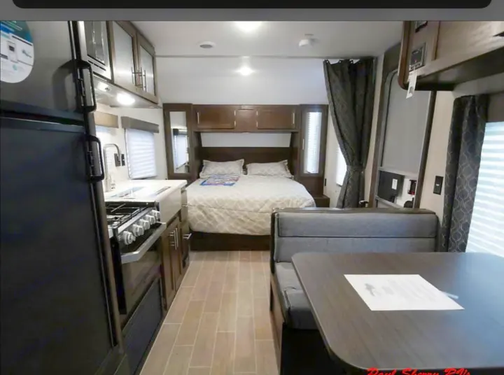 Spacious rv rental interior featuring a full kitchen, cozy bedroom area, and a comfortable dinette.. Forest River Cherokee Grey Wolf 22MKSE 2020
