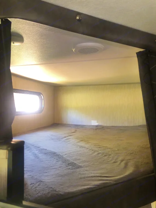 Cozy RV rental bunk bed with natural light from window and ceiling vent, perfect for a good night's sleep.. Forest River Cherokee Grey Wolf 22MKSE 2020