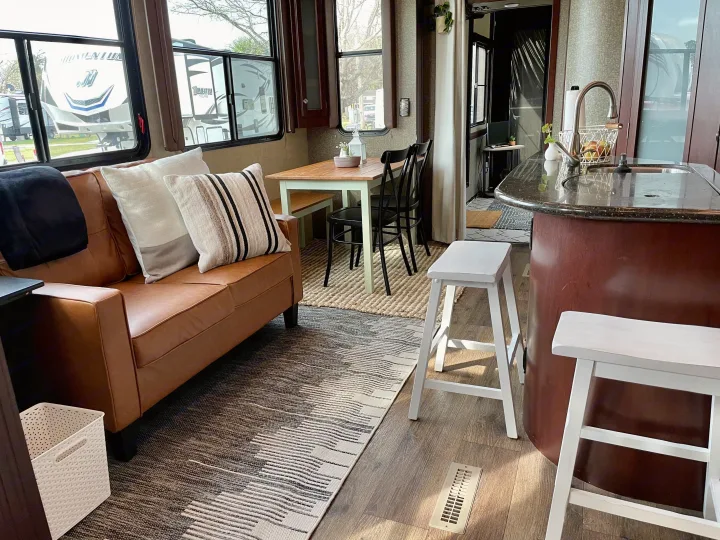 Comfortable RV rental interior showcasing a living area with a couch, dining space, and full kitchen. Ideal for travel.. Heartland RVs Road Warrior Toy Hauler 2015