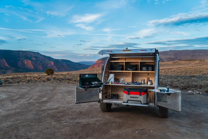 This rv rental teardrop trailer's open kitchen features a stove & cooler, ready for camping amidst scenic mountains. Perfect for adventure.. PINNACLE Pinnacle Summit 2020