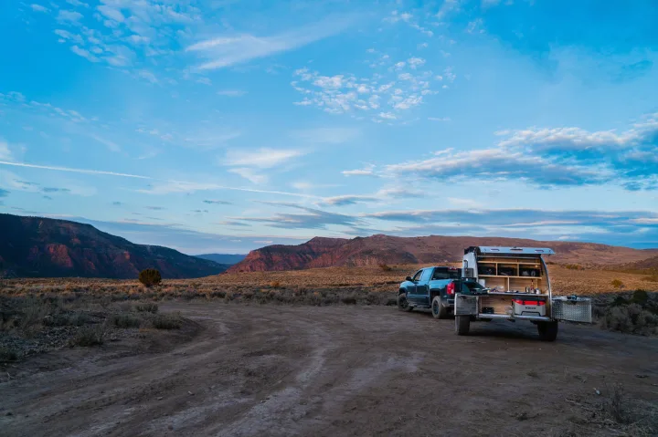 RV rental truck with an open camper kitchen set up in a vast desert landscape at sunset/sunrise. Remote camping adventure awaits!. PINNACLE Pinnacle Summit 2020