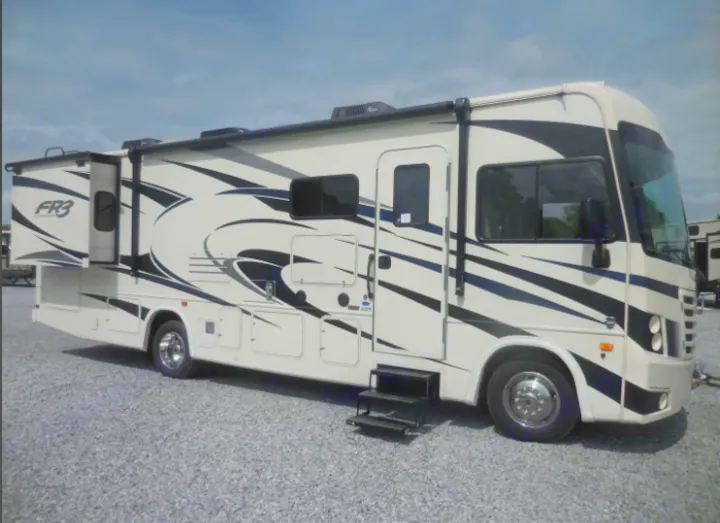 Spacious cream FR3 motorhome, perfect for your next RV rental adventure. Parked on gravel under a cloudy sky.. Forest River FR3 30DS 2020