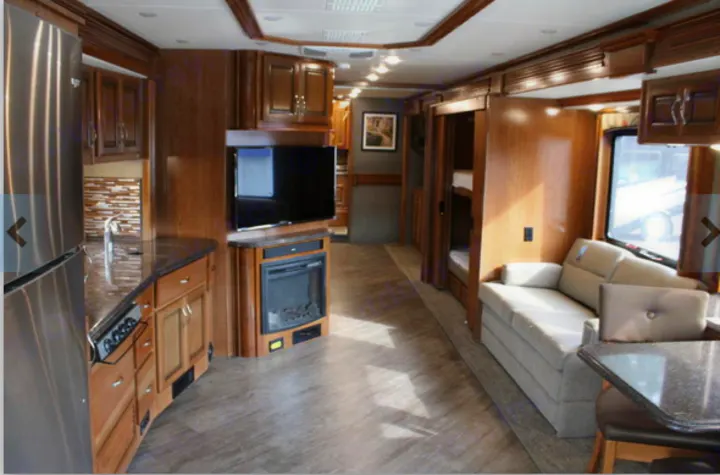 Spacious RV rental interior: modern kitchen, living area with fireplace, bunk beds, and dinette for family comfort.. Fleetwood Pace Arrow 2018