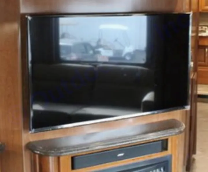 A spacious RV rental interior features a large flat-screen TV, soundbar, and fireplace, offering comfortable entertainment.. Fleetwood Pace Arrow 2018