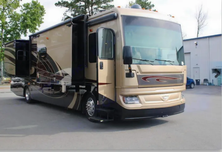 Tan motorhome RV rental, showcasing extended slide-outs, open door & steps, parked outdoors.. Fleetwood Pace Arrow 2018